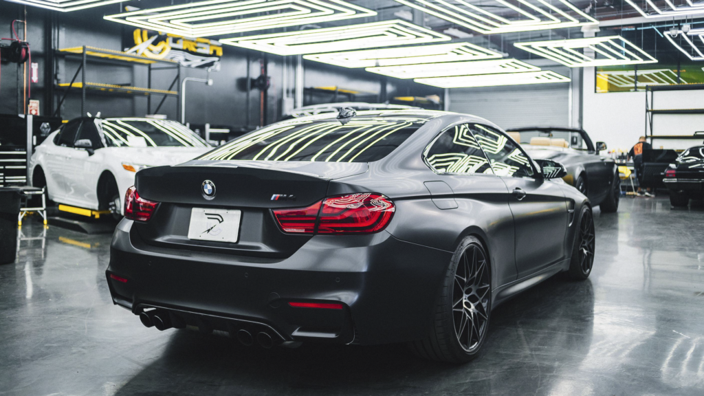 a photo of a black car in a workshop