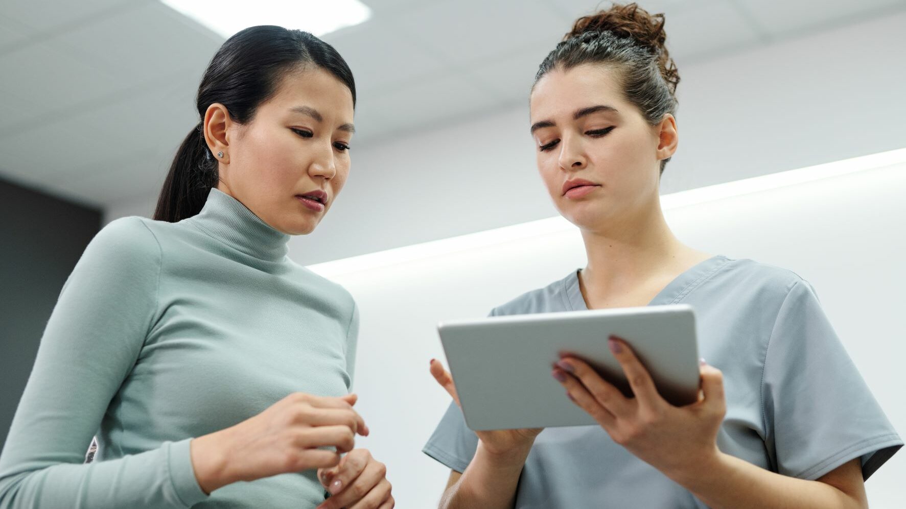 Two women looking at an computer tablet.