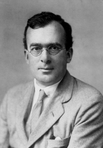 Black and white portrait of Douglas Rayner Hartree, a white man with dark hair wearing glasses and a suit.