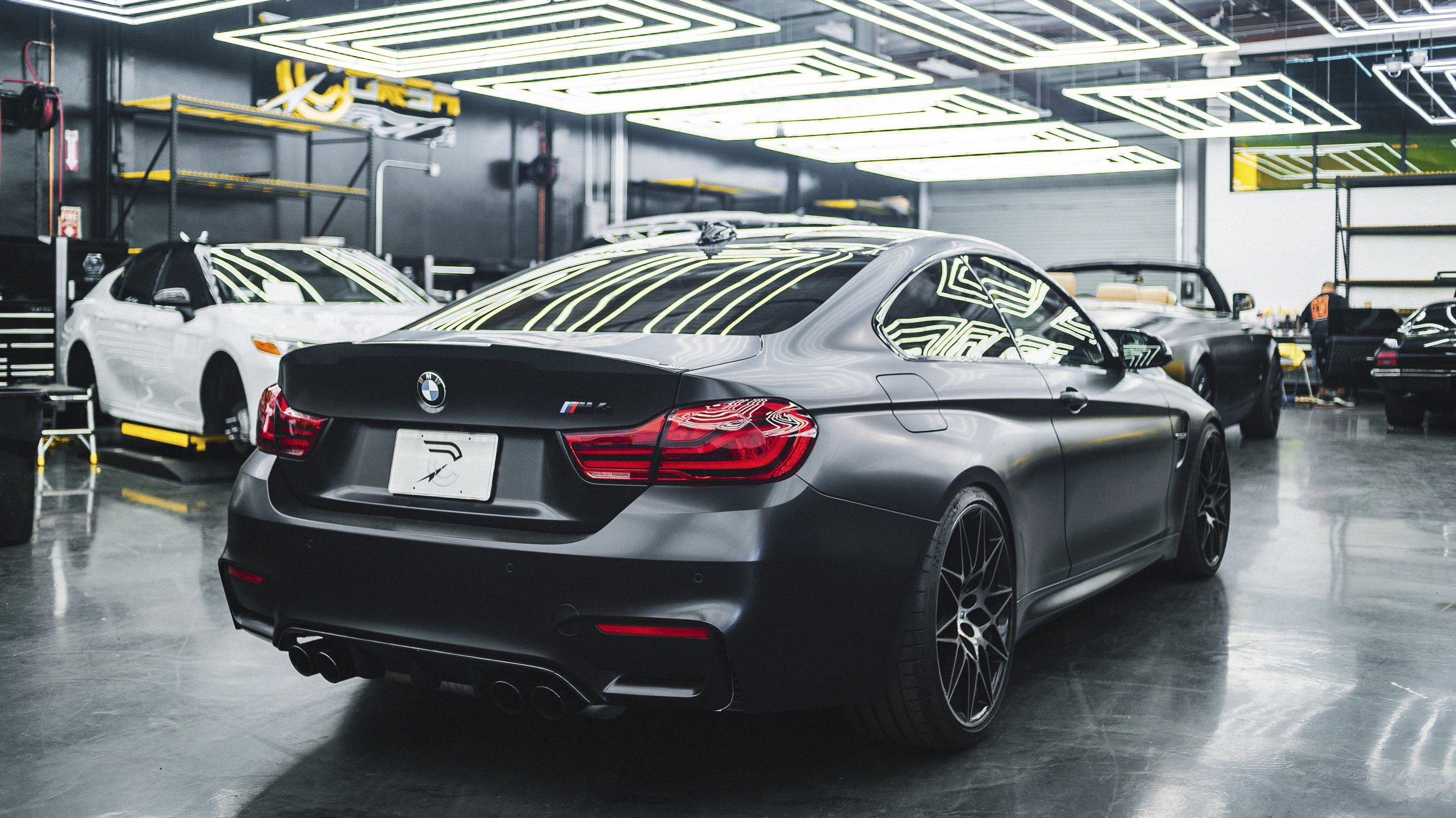 A black car on a factory floor.