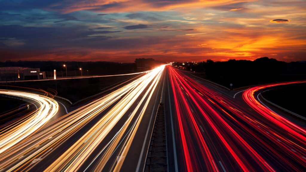 Light trails on motorway at night,  long exposure abstract urban background at sunset.
