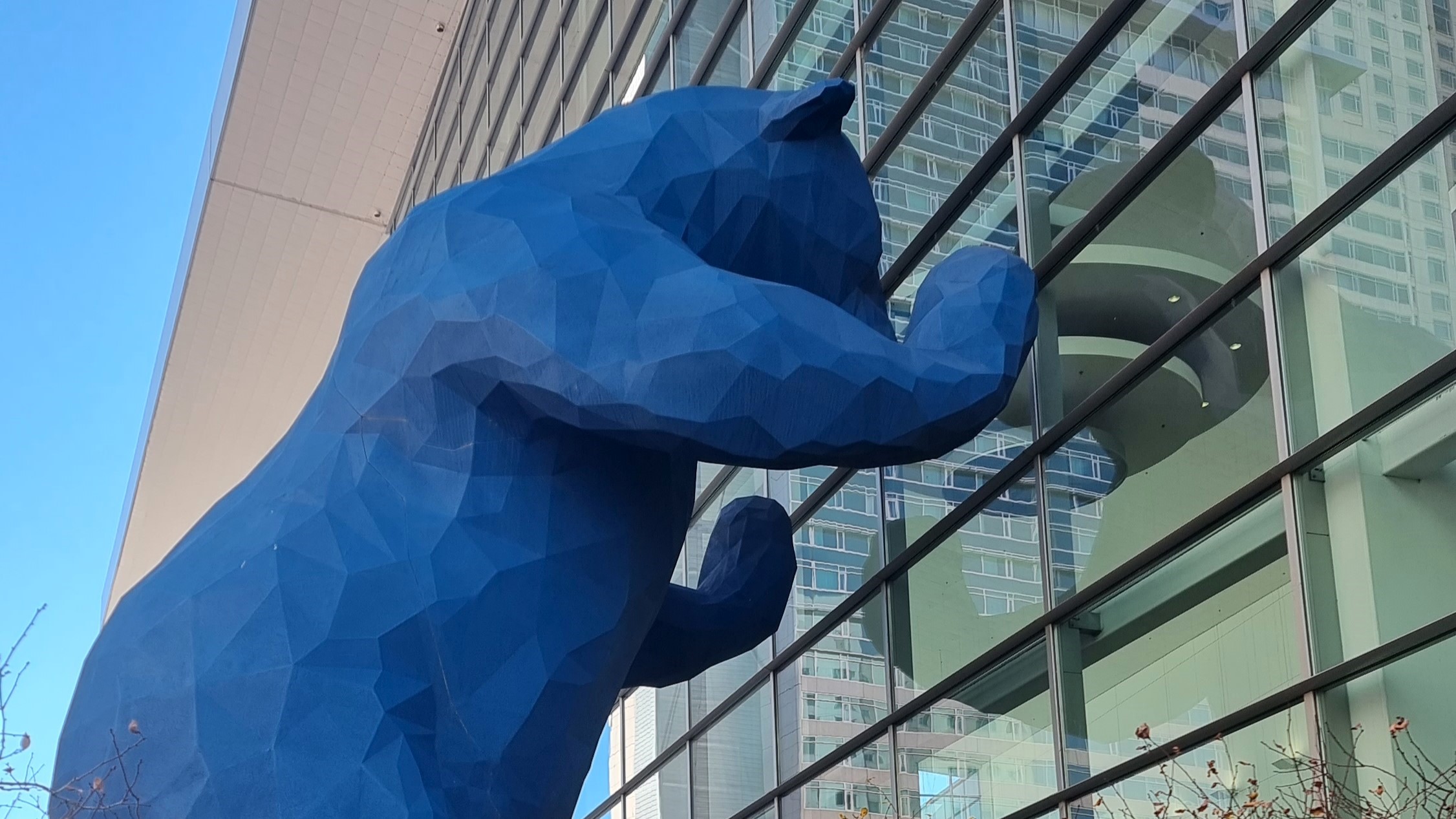 Blue Bear Sculpture leaning against exterior windows of Colorado Convention Centre,Denver.