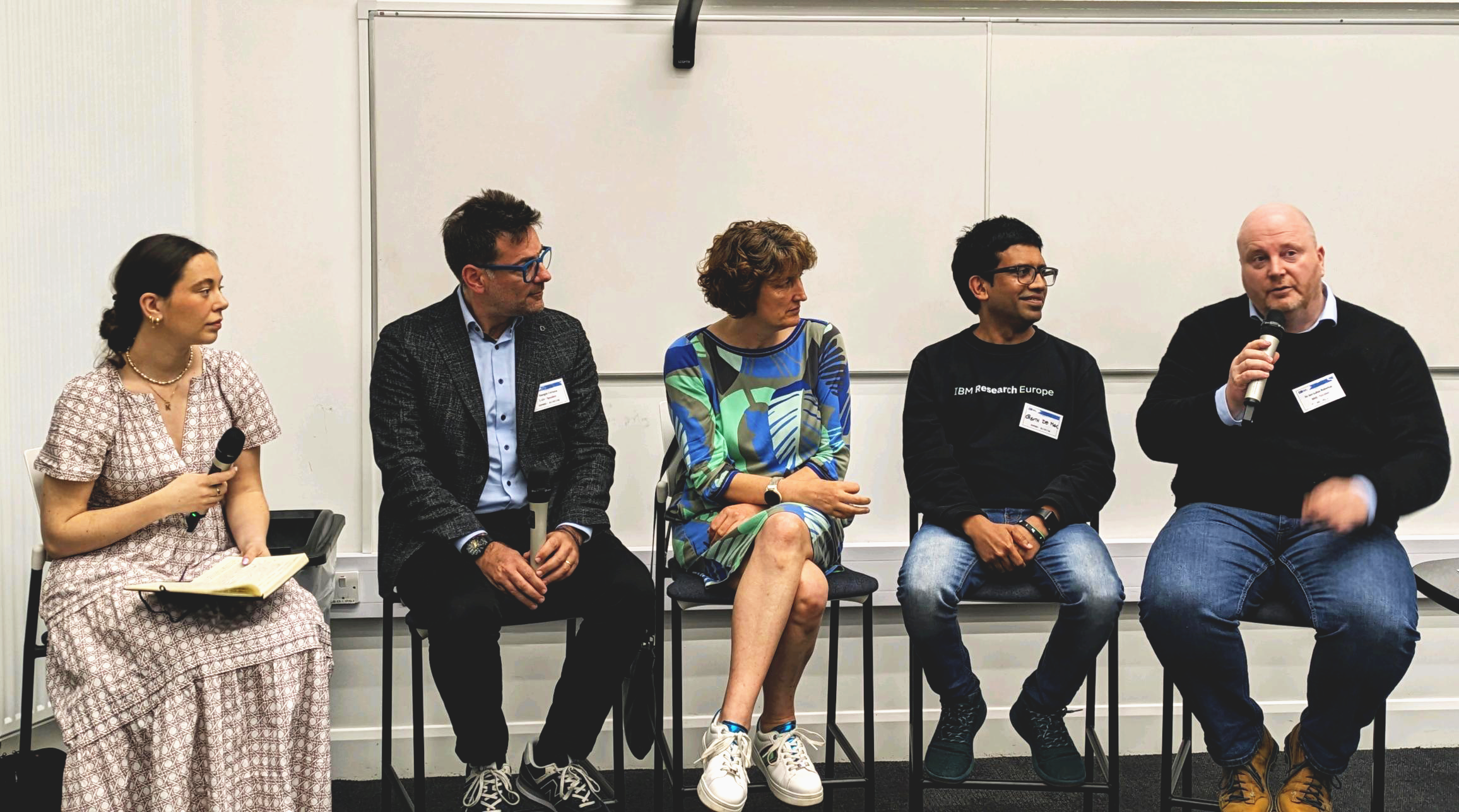 group shot of industry leaders discussing a question on a panel. there are 5 people